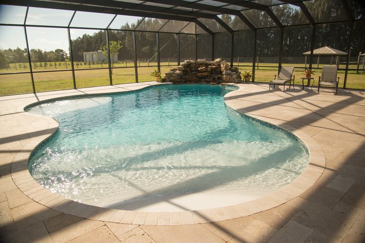 an empty swimming pool in the middle of a large open area with sun shining on it