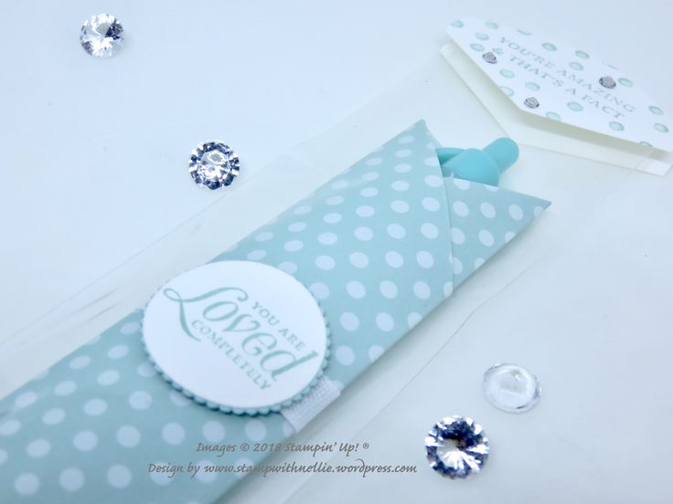 a blue and white polka dot tie laying on top of a table next to some jewels