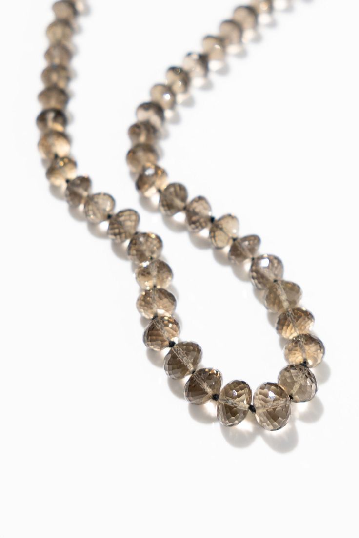 Add a touch of elegance to your wardrobe with our Smokey Quartz Bead Necklace. This beautiful necklace adds a touch of sophistication yet playfulness to any outfit. Perfect for layering or standing alone, this necklace is the perfect addition to your jewelry collection. 19.5 inches - 22.5 inches adjustable length Strung on thread Gold plated over sterling silver clasp Long Single Strand Beaded Necklace, Elegant Double Strand Gemstone Beads Necklaces, Elegant Multi-strand Gemstone Beaded Necklaces, Luxury Multi-strand Gemstone Beads Necklace, Luxury Beaded Necklaces With Round Beads, Elegant Hand-strung Multi-strand Jewelry, Elegant Single Strand Beaded Necklace For Jewelry Making, Single Strand Round Necklace For Party, Elegant Long Single Strand Beaded Necklace