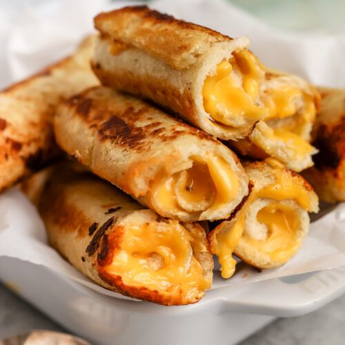 some food that is sitting in a white bowl on a table and it looks like they are stuffed with cheese