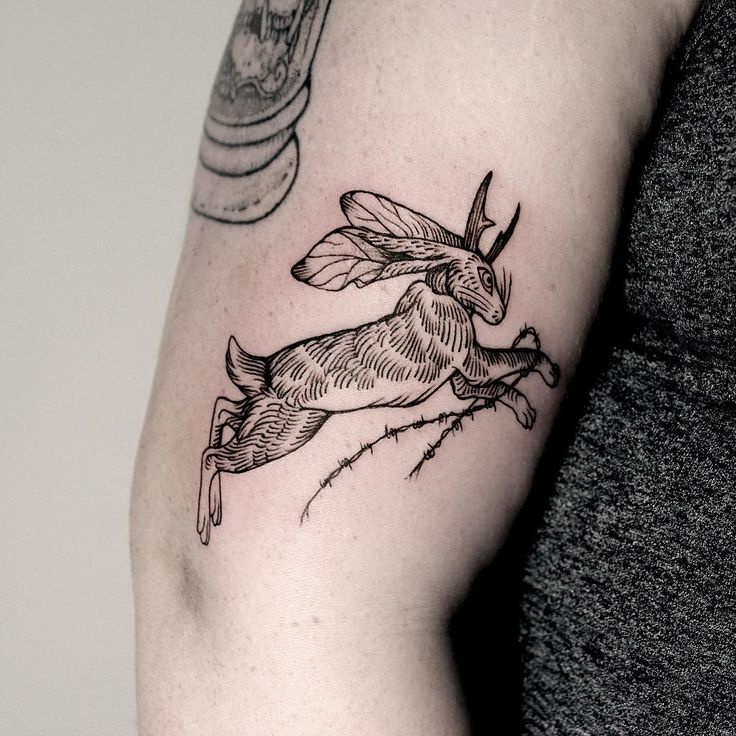 a woman's arm with a tattoo of a rabbit on the left side of her body