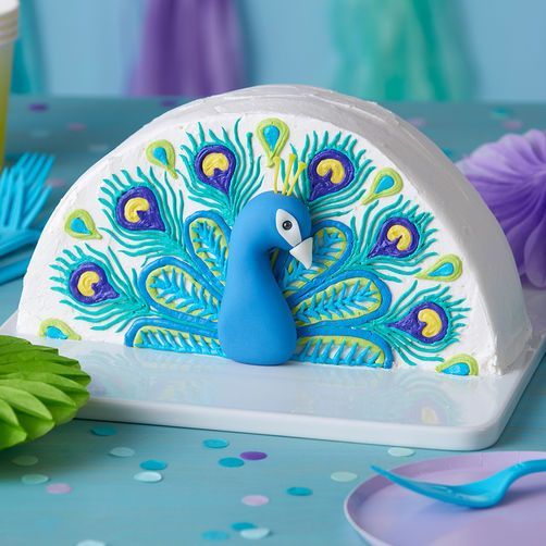 a blue and green peacock figurine sitting on top of a white platter