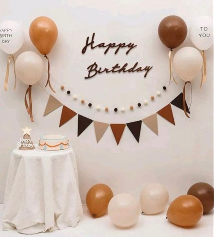 a birthday party with balloons, cake and buntings on the wall in front of it