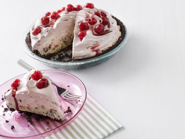 two slices of cake on pink plates with cherries