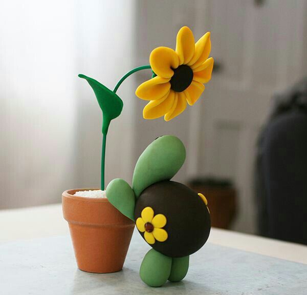 a small potted plant with a yellow flower sticking out of it