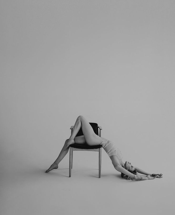 a woman laying on top of a chair with her legs crossed