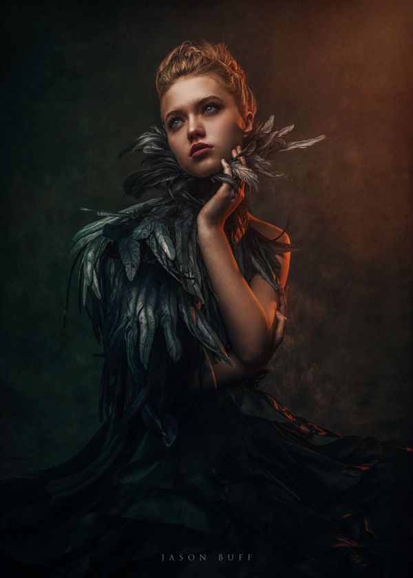 a woman in black dress with feathers on her neck and hands near her face, posing for the camera