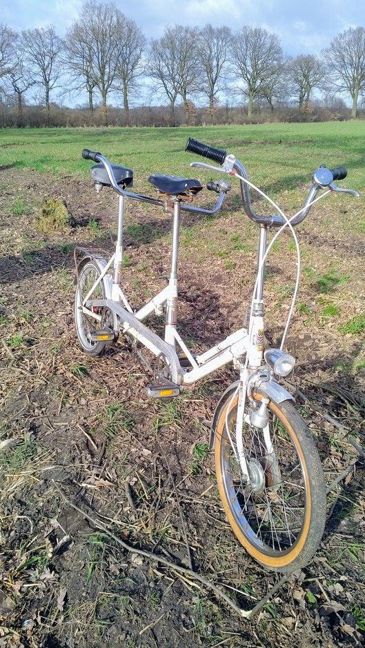 an old bicycle is sitting in the middle of a field with no grass on it