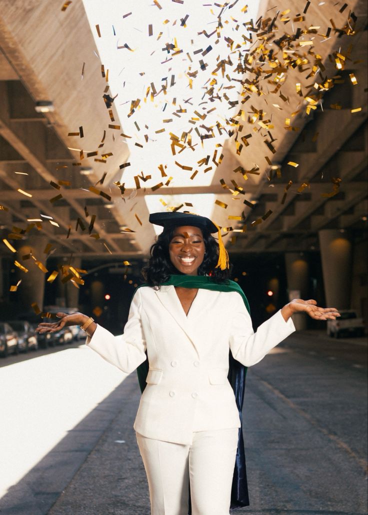 a woman in a white suit and hat with confetti falling from the sky