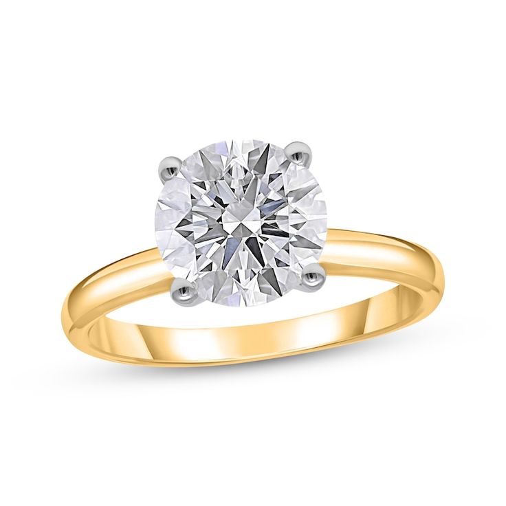 a yellow gold engagement ring with a round cut diamond in the center, on a white background