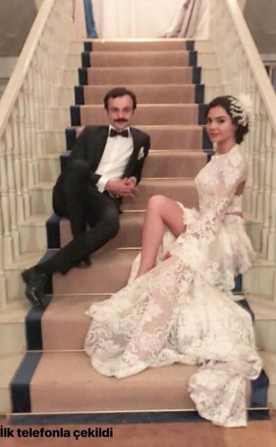 the bride and groom are posing on the stairs