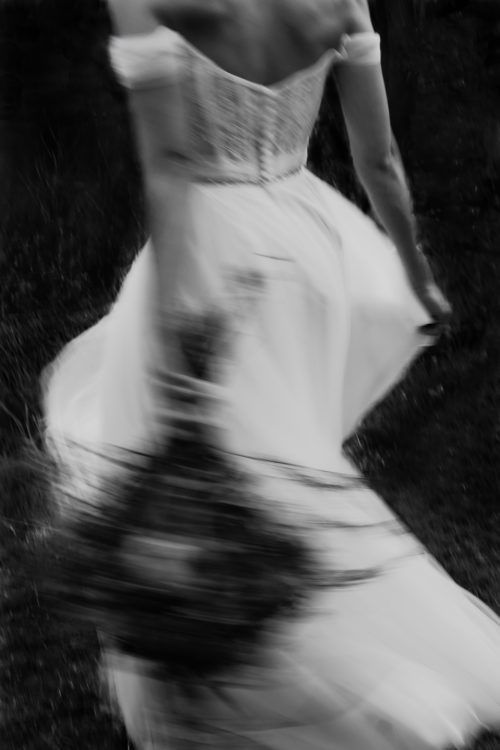 a woman in a dress is walking through the grass