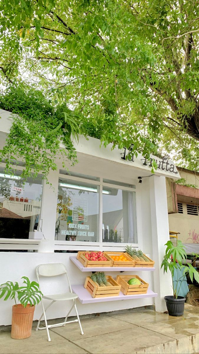 an outside view of a restaurant with food on the counter and trees in the background