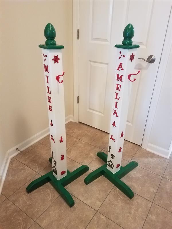 two tall poles with christmas decorations on them in the middle of a floor next to a door