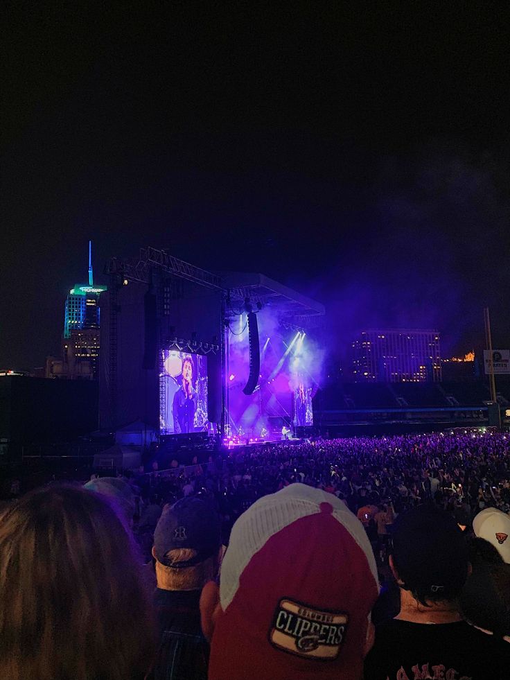 the stage is lit up with purple lights and people are sitting in front of it