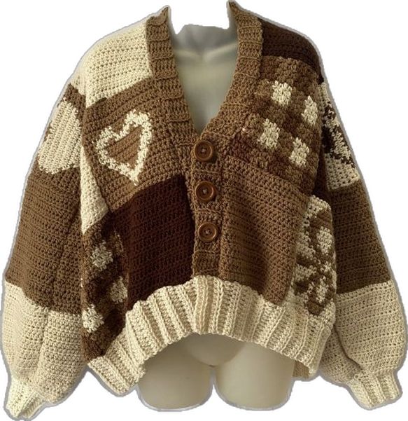 a brown and white knitted cardigan sweater with hearts on the front, sitting on a mannequin's head