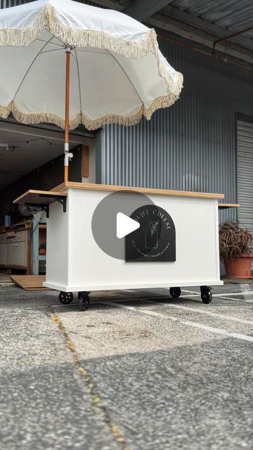 a white box with an umbrella over it sitting in the middle of a parking lot