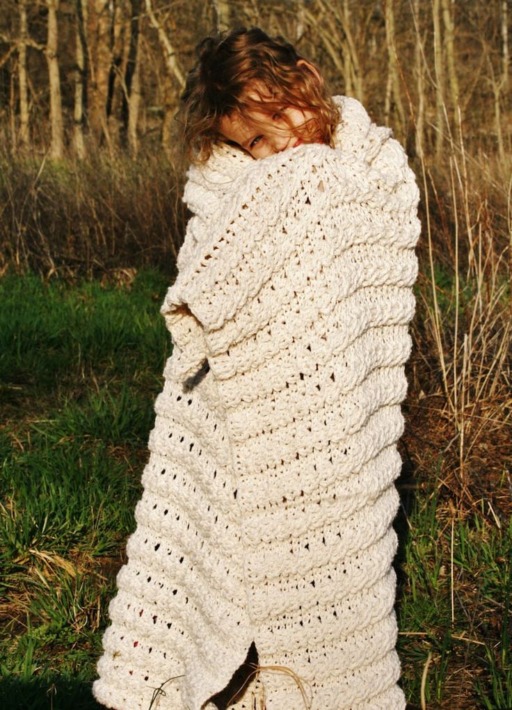 a woman wrapped in a white crochet blanket