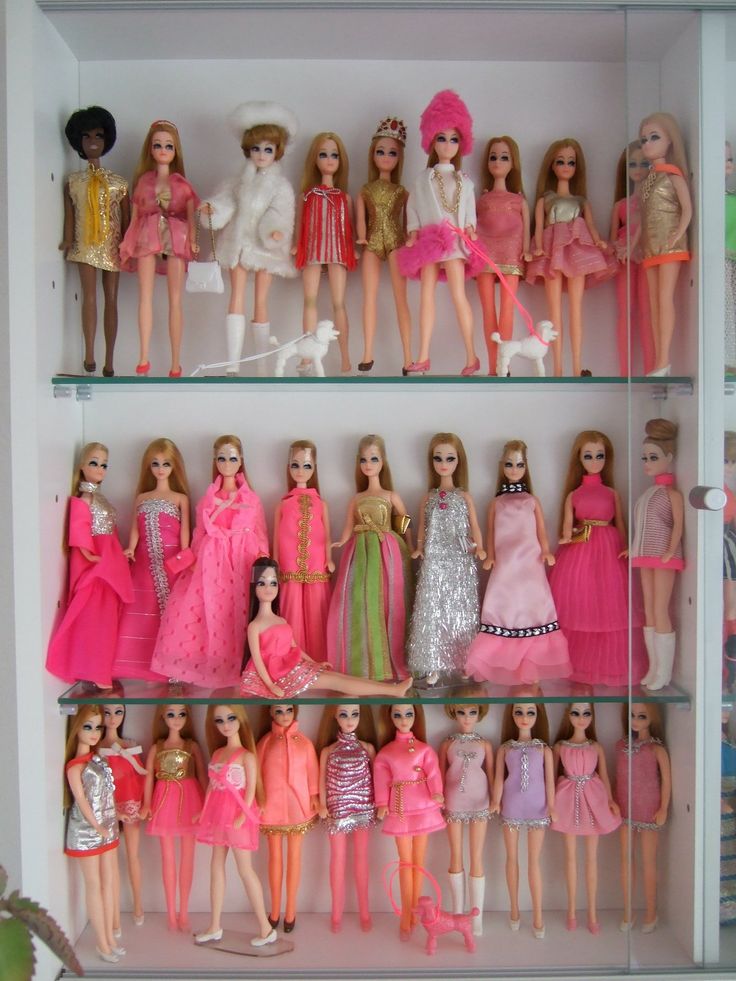 many barbie dolls are lined up on shelves