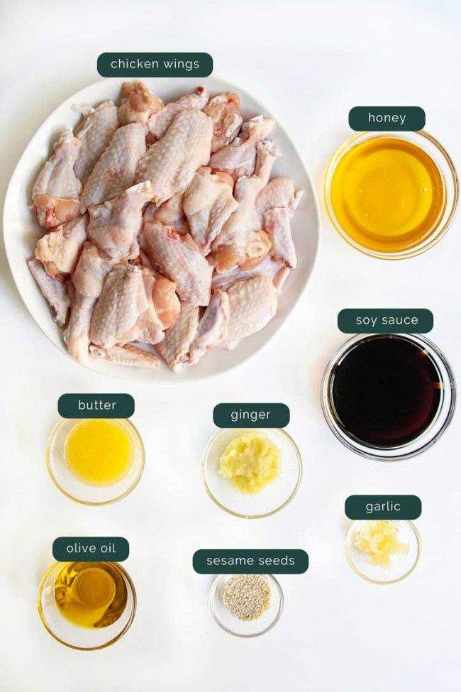 the ingredients for chicken wings are shown on a white plate with green labels around them