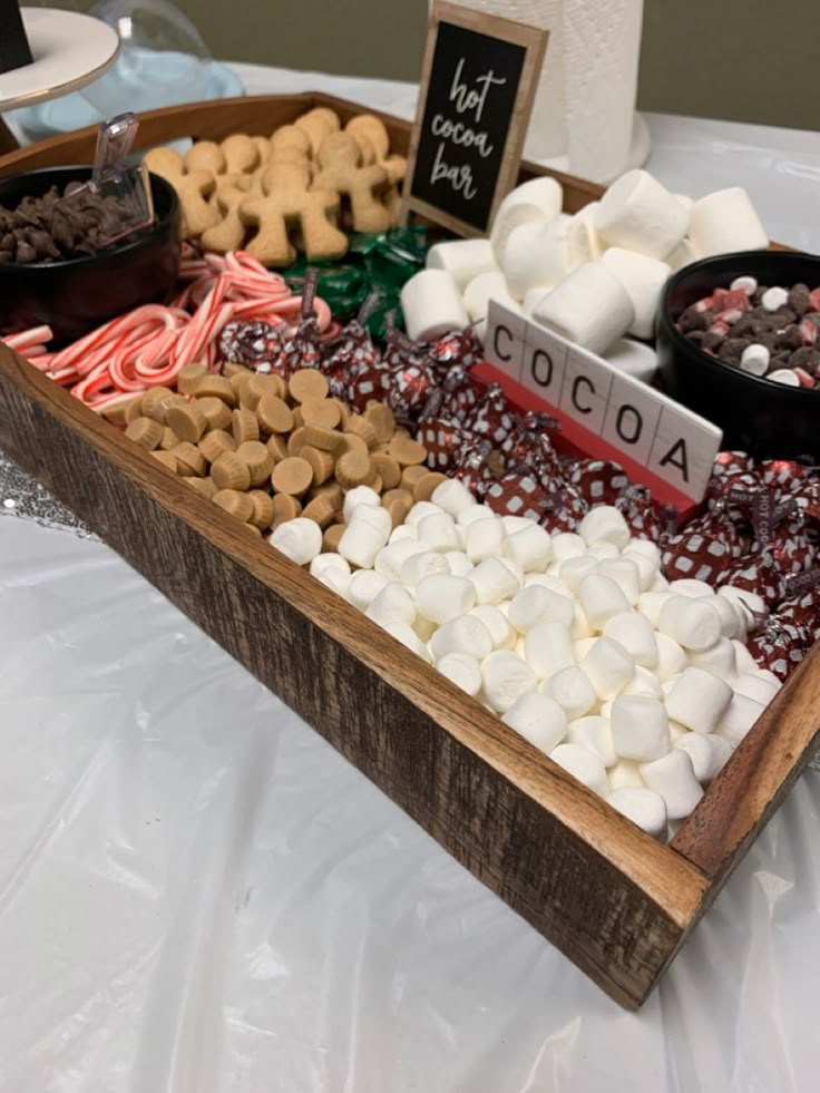 a wooden tray filled with marshmallows and chocolate