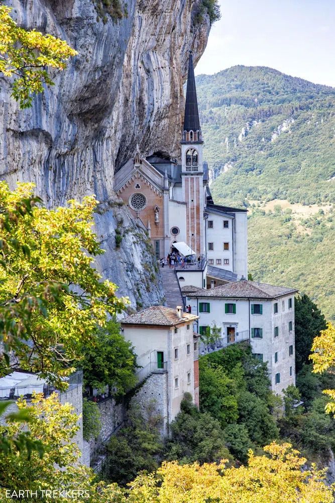 an old church built into the side of a cliff in europe with trees around it