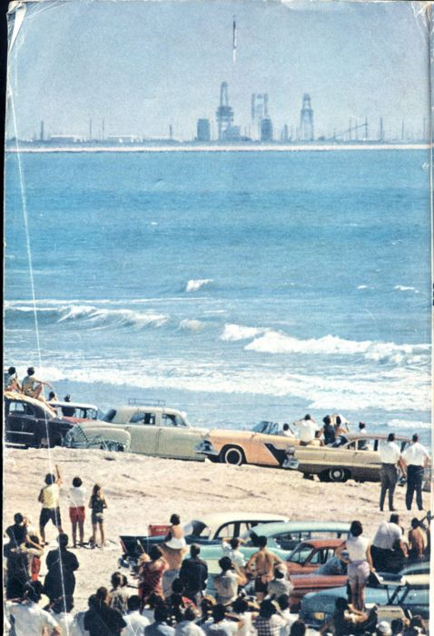 an old photo of cars parked on the beach with people standing in front of them