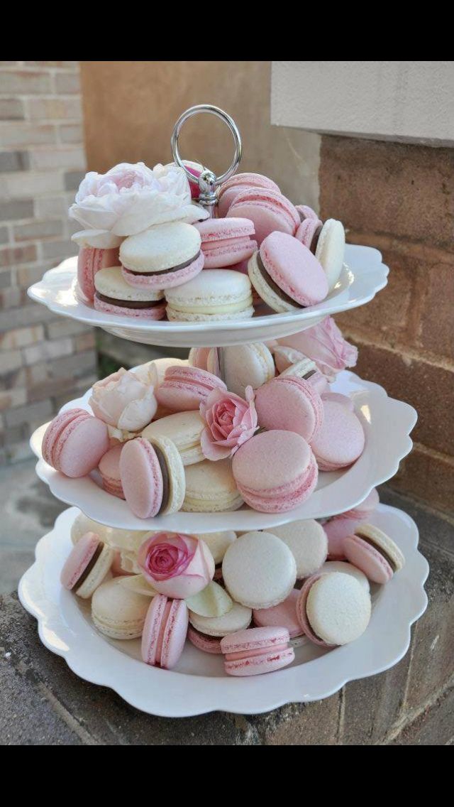 three tiered trays filled with pink and white macaroons