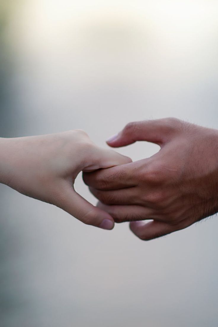 two hands reaching out towards each other to touch the fingers of another person's hand