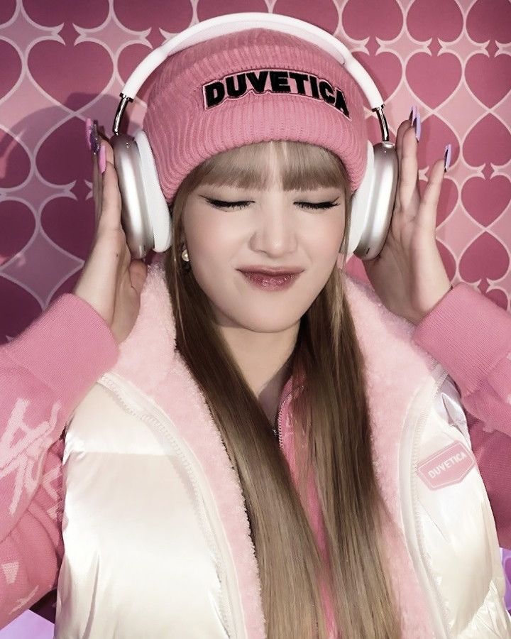 a girl wearing headphones and a pink hat with the word duvettch on it