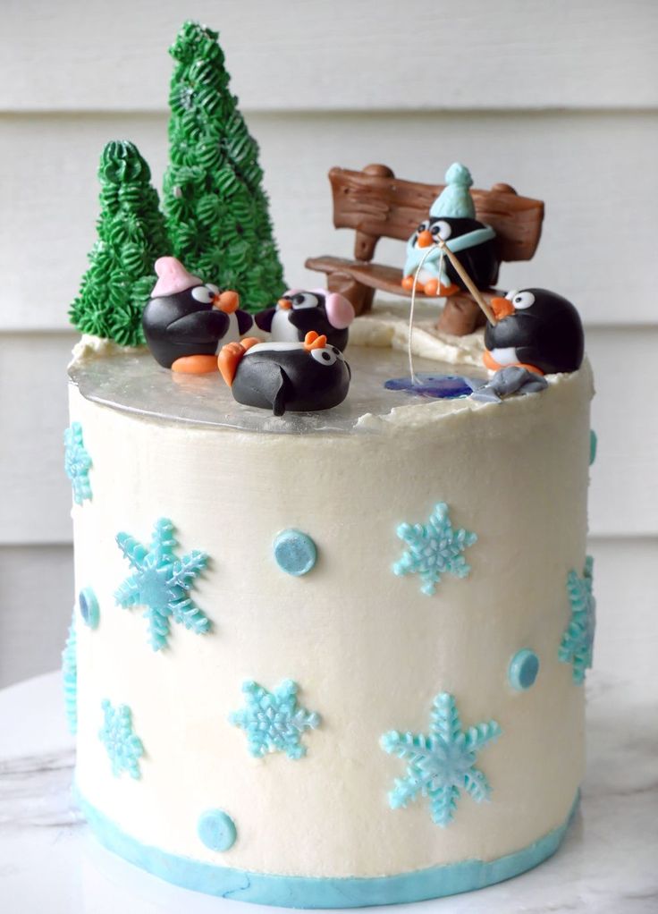 there is a cake decorated with penguins and snowflakes on the top of it