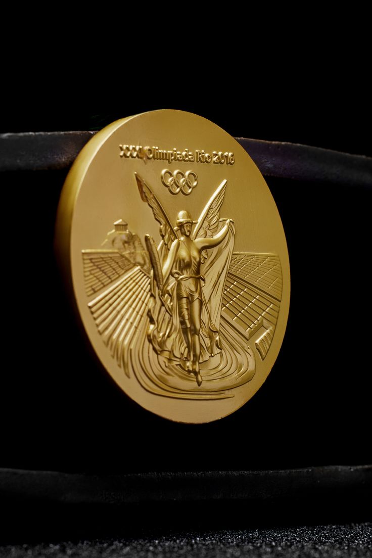 an olympic gold medal is displayed on a black surface in front of a dark background