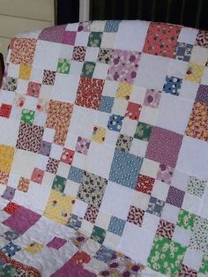 a woman is holding up a quilt made from old patchwork fabrics and fabric material