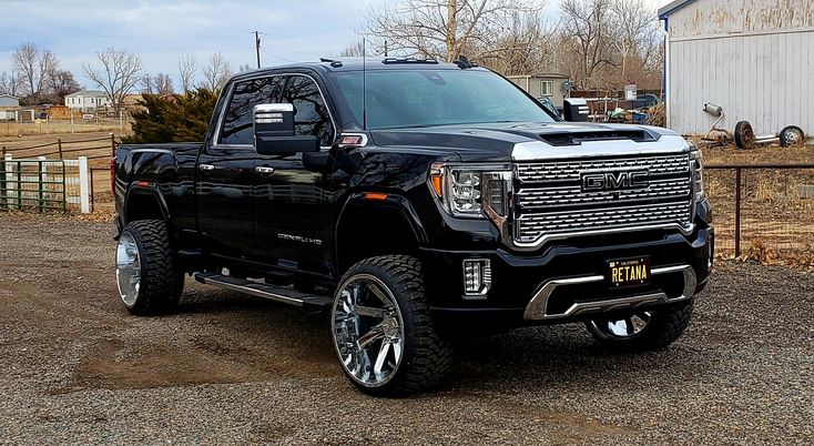 a black truck parked in front of a barn