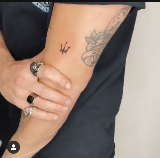 a woman's arm with a tattoo on it and two rings around her wrist