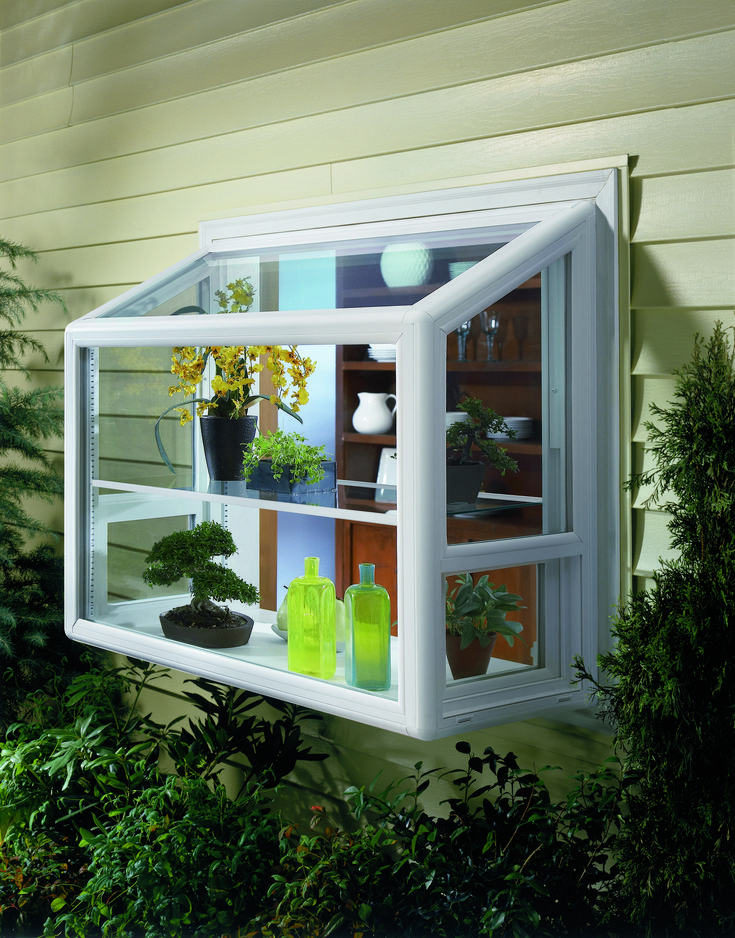 an open window with plants and vases in it on the side of a house