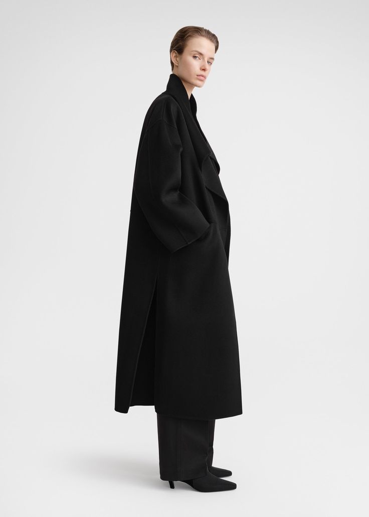 Signature coat crafted from TOTEME's soft doublé fabric – a blend of responsibly sourced wool and cashmere that's created by hand-stitching two fine layers together to achieve a double-faced finish with clean seams. It has an oversized silhouette with easy-to-style shawl lapels, dropped shoulders, and an open front that makes it perfect for layering, then is complete with inseam pockets and side slits. Coordinate it with the Long doublé scarf in the same color. Luxury Oversized Wool Coat With Long Sleeves, Classic Black Cashmere Wool Coat, Modern Black Wool Coat With Concealed Placket, Oversized Wool Coat With Lapel Collar For Formal Occasions, Black Outerwear With Structured Boning And Lapel Collar, Black Cashmere Wool Coat For Winter, Winter Black Cashmere Wool Coat, Chic Long Cashmere Outerwear, Oversized Wool Coat With Notch Lapel For Formal Occasions