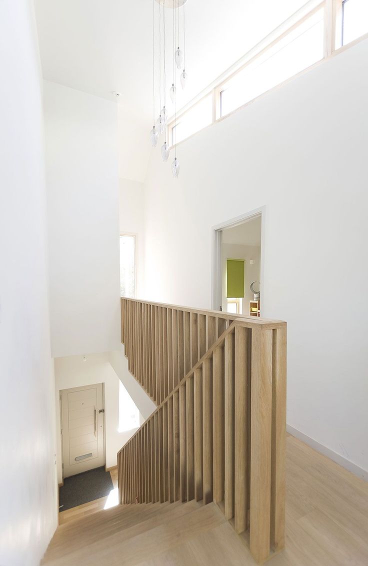 an empty room with wooden stairs and white walls