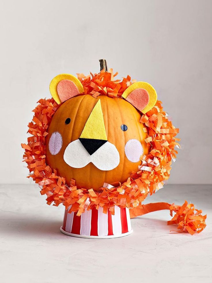 a lion pumpkin decorated with orange leaves