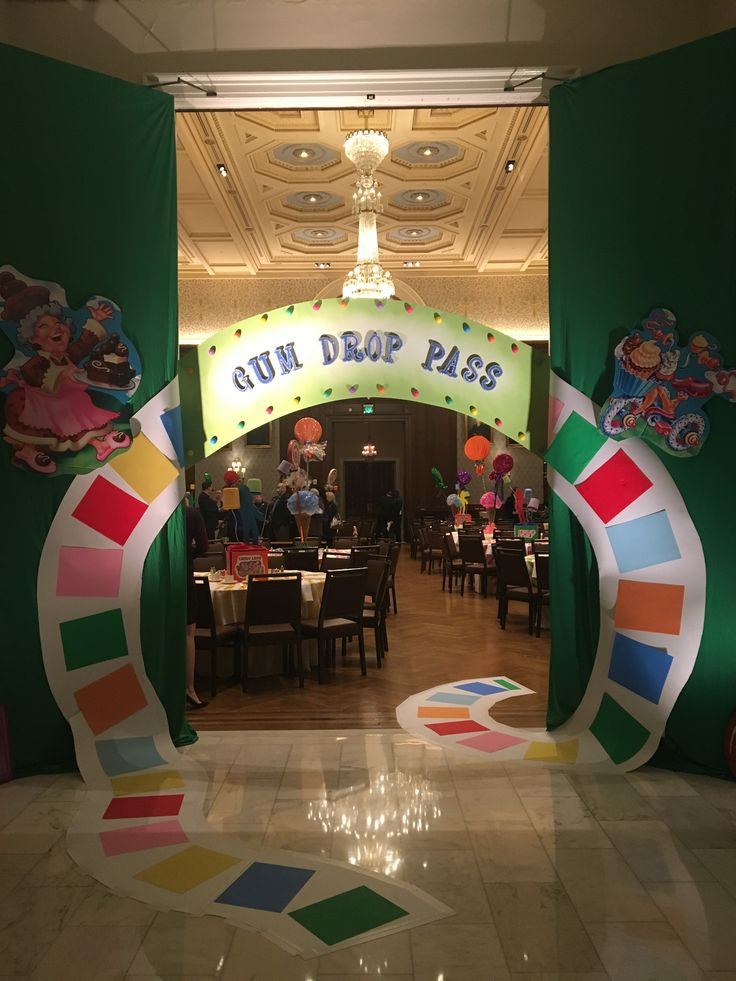 the entrance to an indoor restaurant decorated with rainbow colors and decorations for children's birthdays