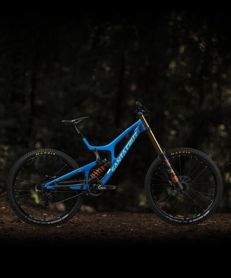 a blue mountain bike in the dark with trees in the backgroung area