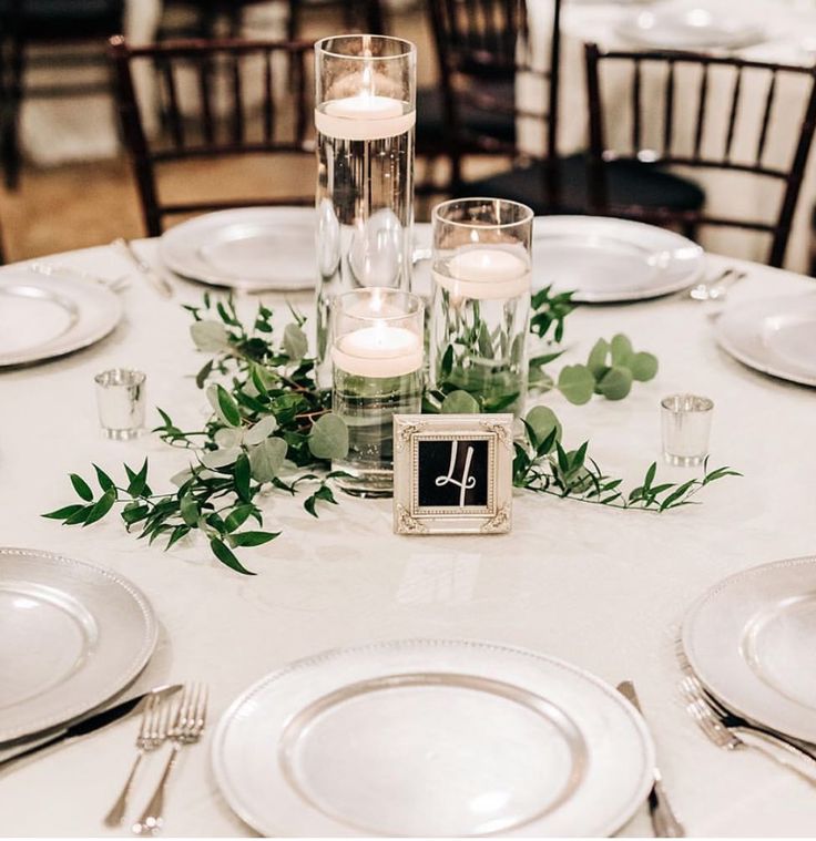 the table is set with candles, plates and silverware for an elegant wedding reception