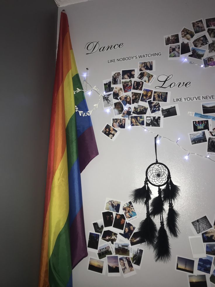 there is a wall with pictures on it and a rainbow flag in the corner next to it