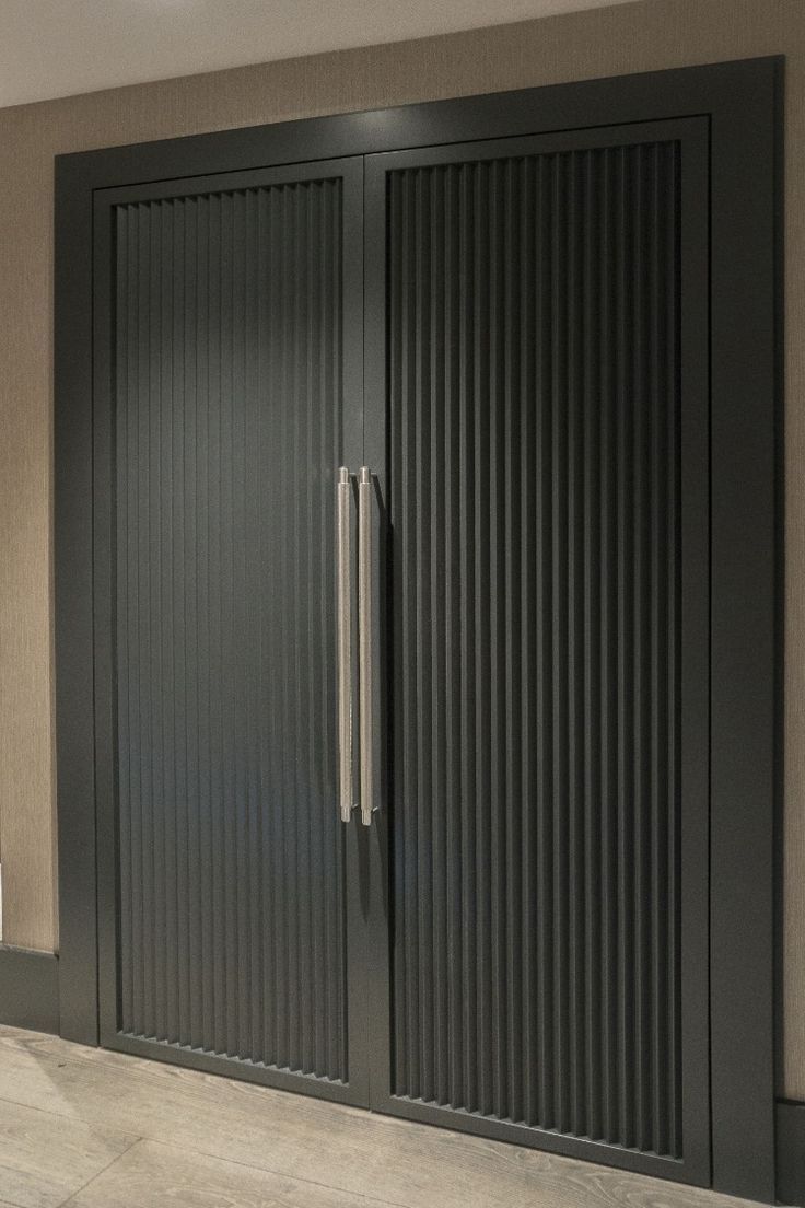 a large black door in the corner of a room