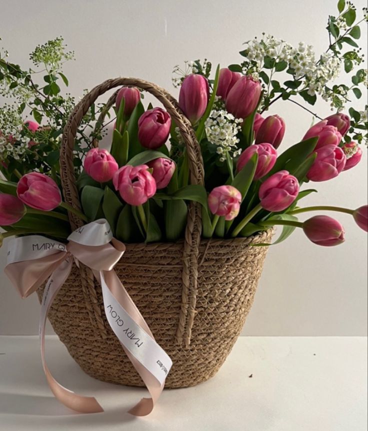 a basket filled with lots of pink tulips