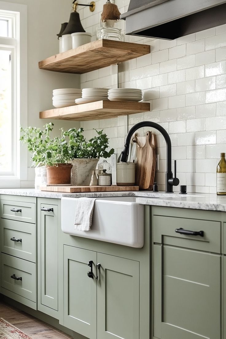 a kitchen with green cabinets and white subway backsplash, open shelving above the sink