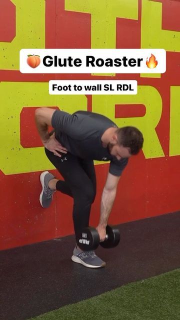 a man is doing squats with dumbbells in front of a red and yellow wall