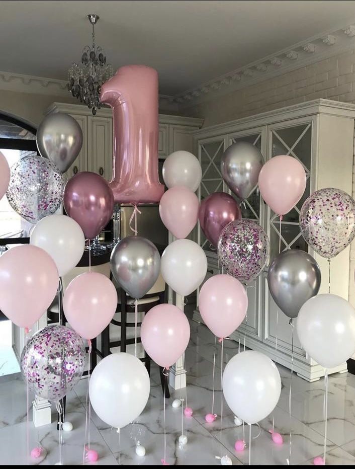 a room filled with lots of balloons and a number one