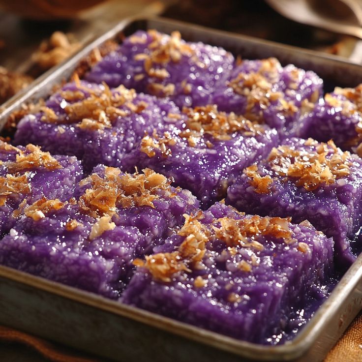 a pan filled with purple dessert sitting on top of a table