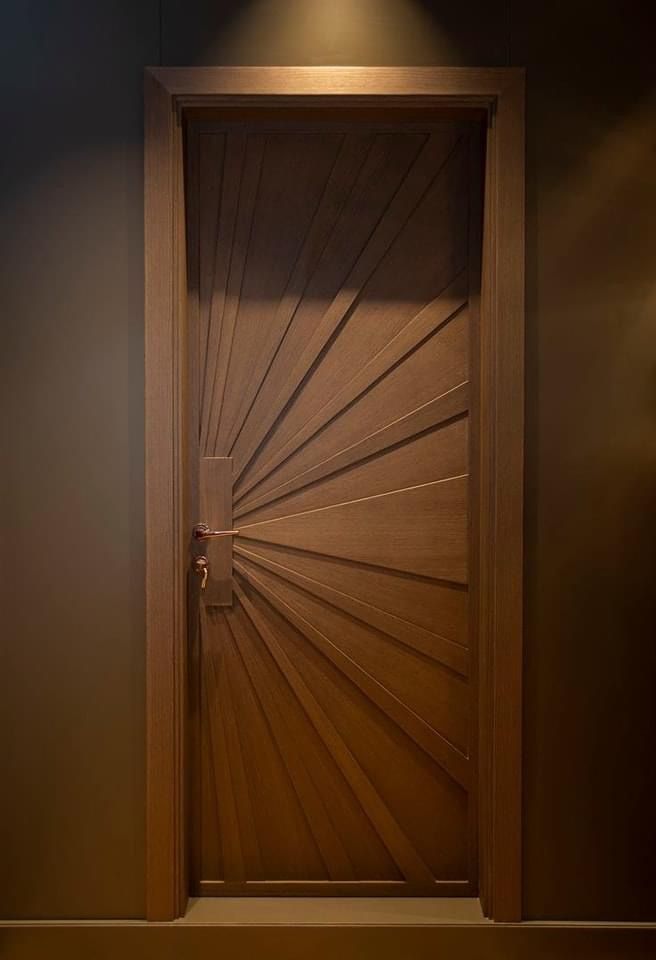 an open wooden door in a dark room with light coming through the opening and casting shadows on the wall